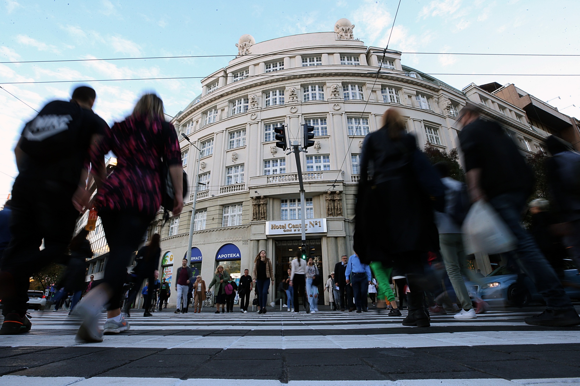 Rusi u Srbiji osnovali 2.321 kompaniju ljudi prelaze preko pješačkog prelaza slika napravljena ogozdo u pozadini zgrada na ulici desetak ljudi sunčan dan