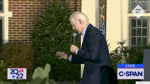 gaf Joea Bidena predsjednik SAD spotaknuo se tokom držanja govora o kabl na bini govornica biden iz profila rukama drži ravnotežu tamn o odijelio mikrofon u ruci