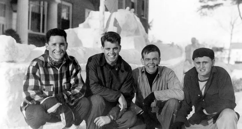 Jezive priče o slavnoj dinastiji Kennedy Bobby Kennedy liberalna ikona crnobijela slika četiri mladića kako čuče u snijegu i smiju se u kameru okolo snijeg ulica i zgrada