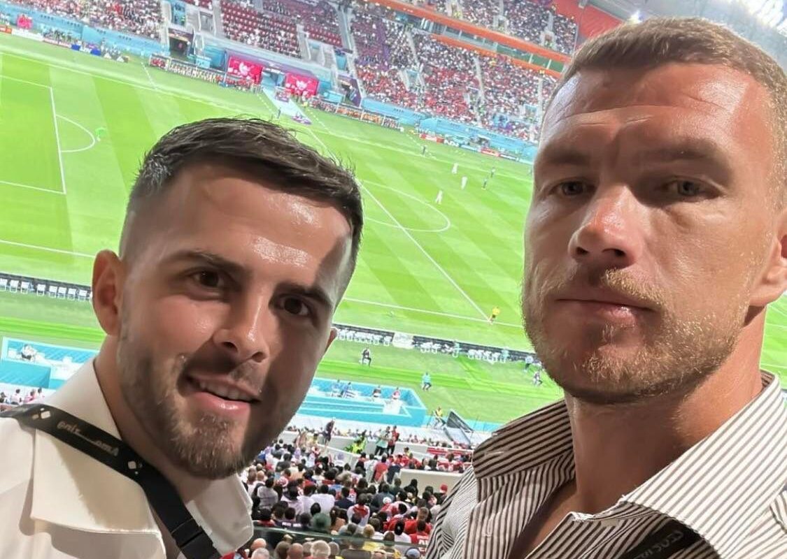 Edin Džeko i Miralem Pjanić gledaju utakmicu iza njih stadion u Dohi igrači na terenu vide im se glave obojica u bijelim majicama pune tribine