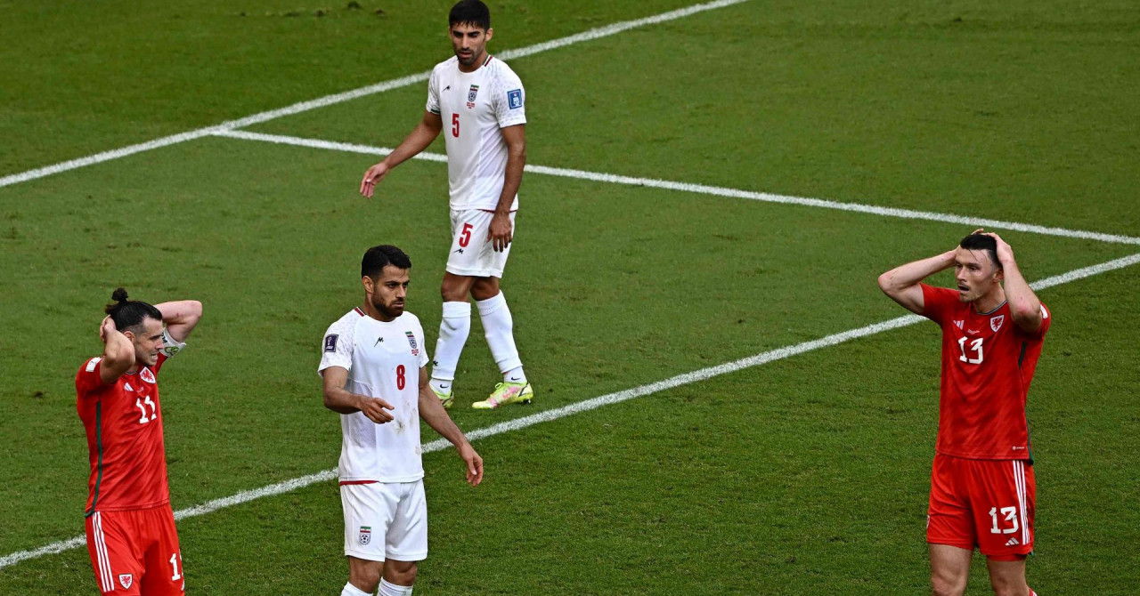 Velški navijač umro u Kataru na terenu fudbaleri Velsa i SAD crveni i bijeli dresovi njeh nekoliko drže se za glavu gol u pozadini