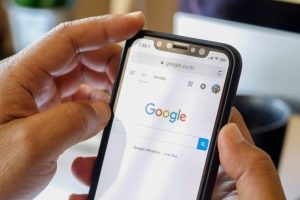 pretraživanja na Googleu drži mobitel u obje ruke google