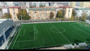 novi teren na stadionu Grbavica snimljen iz zraka nova vještačka trava iscrtan teren svježe zgrade okolo lijevo dvorana Goran Čengić sunčan dan
