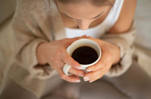prazan stomak žena drži šolju kafe sa obje ruke