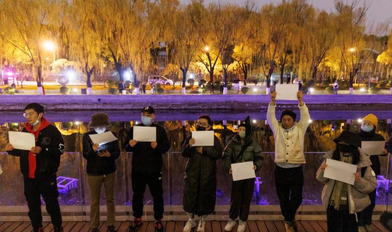 provjeravaju mobitele demonstranti u kini drže transparente