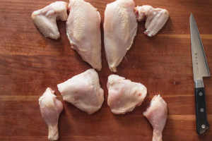kako izrezati pile kao profesionalac komadi piletine izrezani na drvenoj dasci sa strane nož