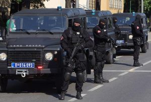 u Beogradu velika akcija policije tri policijska auta Land Rover crna na ulici tablice policije Srbije tri policajca u crnim uniformama sa fantomkama na glavi i puškama u rukama sunčan dan