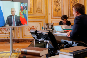 napad atomskom bombom Vladimir Putin i Emmanuel Macron razgovaraju videolinkom ured Macrona on gleda u ekran na kojem je putin u sakou tamne boje obojica, bijele košulje, u uredu mnoštvo knjiga na stolu ukrasni zidovi zlatna boja žena sjedi u daljini u prostoriji i kuca na računar