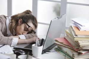 Fizički simptomi stresa umorna žena naslonila glavu na radni sto