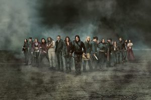 jedna od najpopularnijih serija današnjice Walking Dead završena je glumci iz serije stoje u mraku okolo njih magla na njima poderana odjeća nose oružje ima ih tridesetak