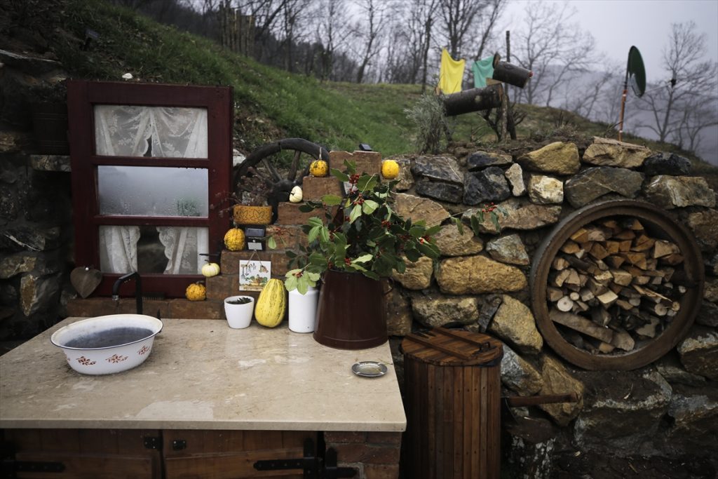 hobbit kućice dvorište kamenje naslagano u zidić metalni lavor cvijeće ogledalo oblačno