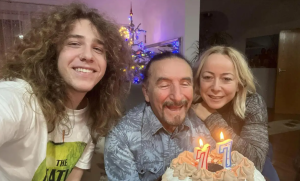 Željko Bebek slavi 77. rođendan na slici Željko Bebek sa suprugom i sinom slave smiju se Bebek drži tortu sa svijećama broj 77 iza jelka u stanu