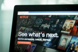 Netflix ima tajni klub gledatelja ekran računara na kojem se vidi prva stranica Netflixa na engleskom piše pogledaj šta je sljedeće iza su mini slike isječci izu filmova i serija računar u svijetlom prostoru koji je zamagljen