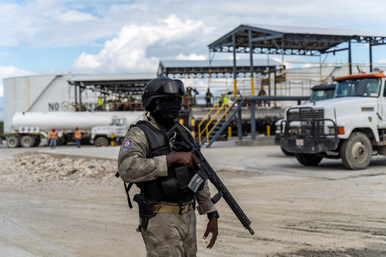grad iz pakla Vojnik sa maskom i kacigom na glavi stoji u uniformi sa puškom iza patori zemlja bijeli automobil terenac oblačno nebo