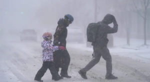 Ekstremna zima dvoje odraslih i dijete prelaze cestu po snježnoj oluji