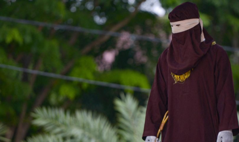 šerijatski odred za bičevanje žena u smeđem hidžabu zelenilo