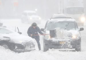 bez struje čovjek čisti lopatom snijeg sa auta i ceste pada snijeg sad