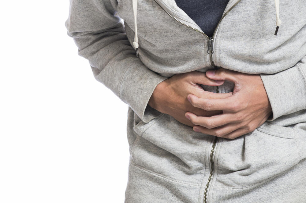 gušterača u problemu muškarac u dukserici previja se zbog bolova u stomaku