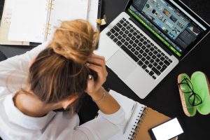 svladati stres žena se drži za glavu laptop radni sto