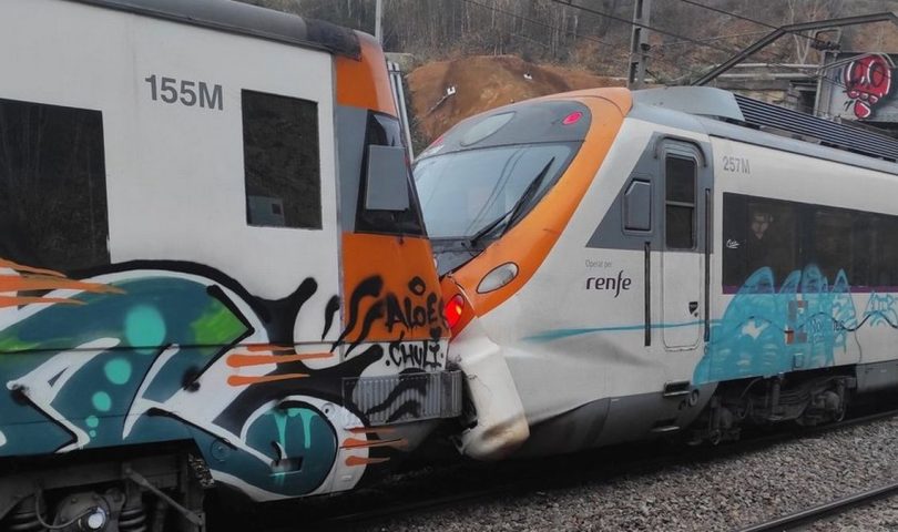 Sudarila se dva voza u Barceloni dva bijela voza prignječene kabine u istoj traci oba imaju narandžaste linije jedan išaran grafitima vidi se pijesak dan