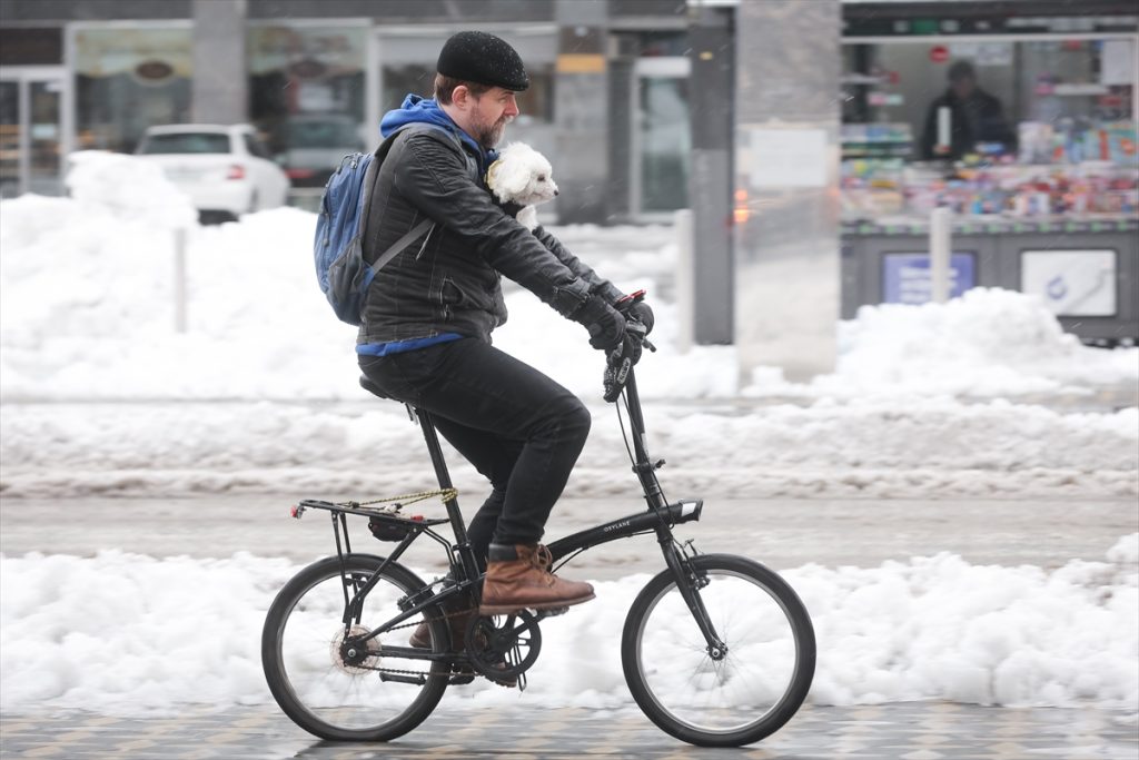 Snježne padavine ne sprečavaju slovence da voze bicikl muškarac vozi u jakni mu pas dan okolo snijeg