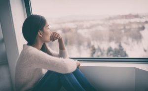 januar žena sjedi pored prozora