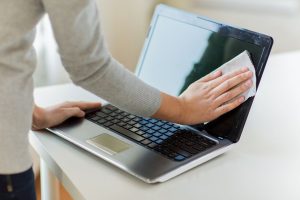 kako očistiti ekran žena čisti krpom ekran laptopa