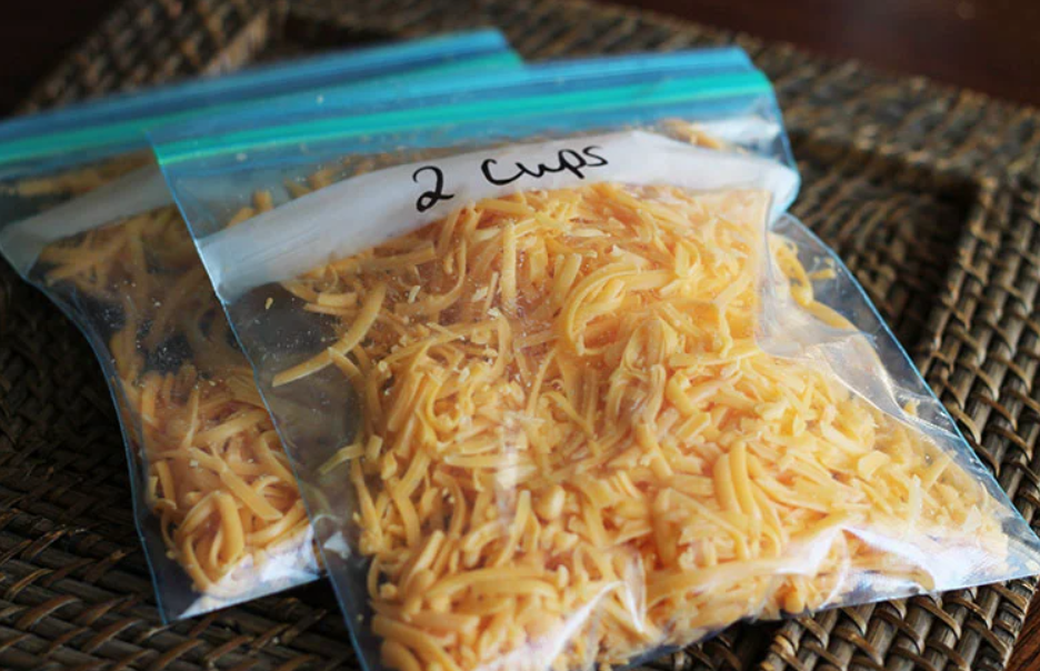 Prije zamrzavanja sir naribajte dvije vrećivce naribanog sira cheddar narandžasti na podlozi pletara