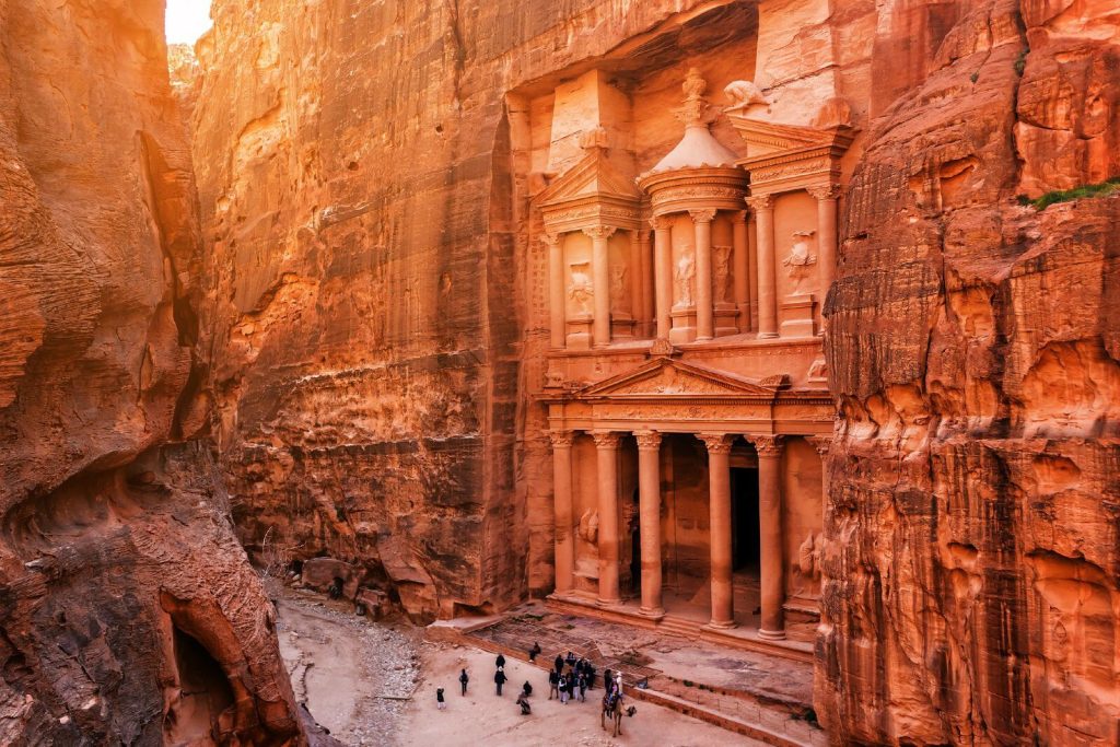 Spektakularni gradovi Petra dan ljudi ispred zdanja u pećinama crvena svjetlost
