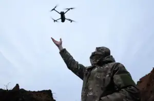 budućnost ratovanja vojnik ispružene ruke pušta dron nebo