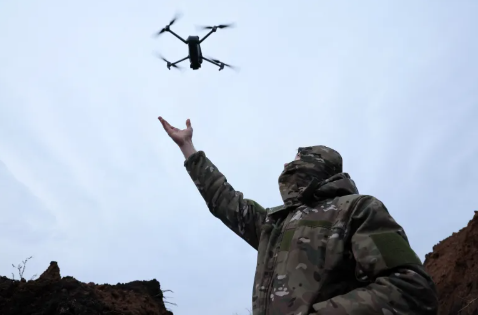 budućnost ratovanja vojnik ispružene ruke pušta dron nebo